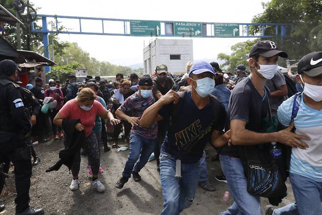 온두라스 이민자들이 1 일(현지시간)  필사적으로 과테말라 코린 토로 국경을 넘고 있다. (AP Photo)