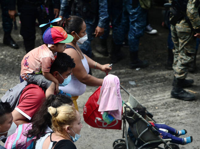 이민자들이 1일(현지시간), 온두라스 코린 토 국경에서 과테말라로 들어가기 위해 경찰 울타리를 통과하고 있다.(Photo by ORLANDO SIERRA /