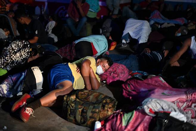 1일(현지시간) 온두라스 국경을 넘은 이민자들이 과테말라 엔트 레 리오스에서 쪽잠을 자며 쉬고 있다. (Photo by Johan ORDONEZ / AFP)