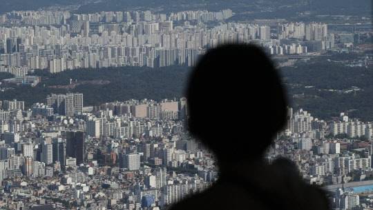 한 시민이 서울 송파구 롯데월드타워 서울스카이에서 송파구 일대 아파트 밀집 지역을 바라보고 있다. <연합뉴스>