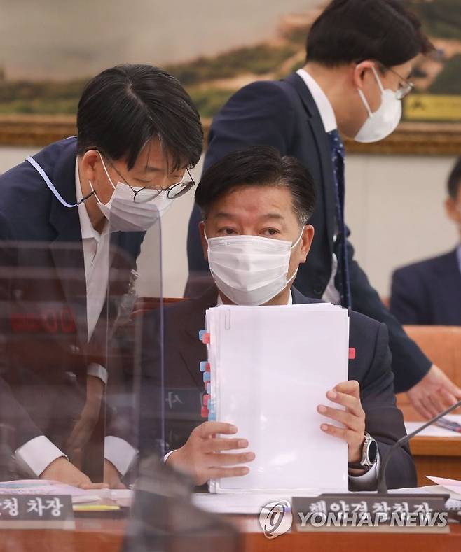 관계자와 이야기하는 김홍희 해양경찰청장 (서울=연합뉴스) 진성철 기자 = 김홍희 해양경찰청장이 8일 오전 서울 여의도 국회에서 열린 농림축산식품해양수산위원회의 해양수산부에 대한 국정감사에서 관계자와 대화를 나누고 있다. 2020.10.8 zjin@yna.co.kr