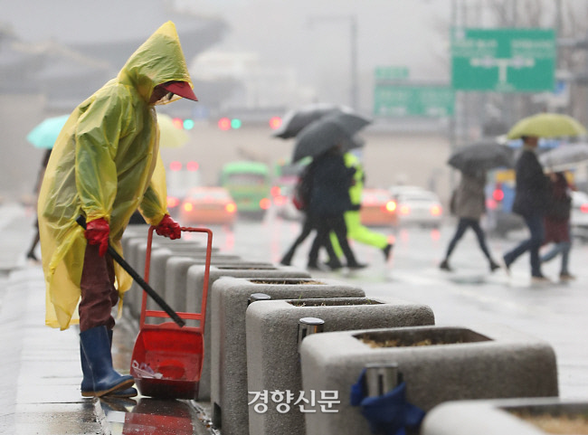 환경미화원이 서울 광화문광장에서 비옷을 입고 청소를 하고 있다. 권도현 기자 lightroad@kyunghyang.com