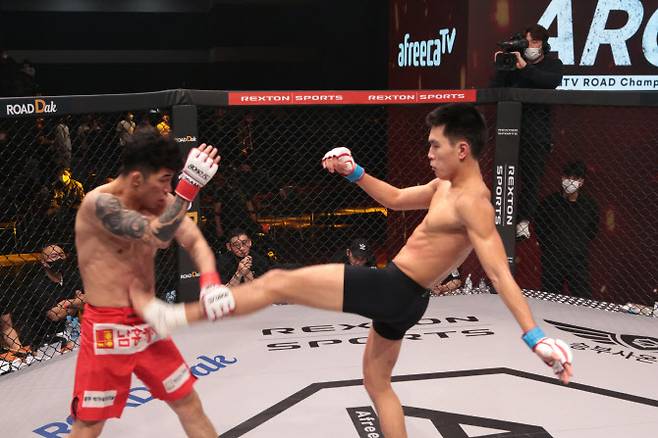 박시원(오른쪽)이 박찬수에게 긴 다리를 이용한 미들킥을 날리고 있다. 사진=로드FC