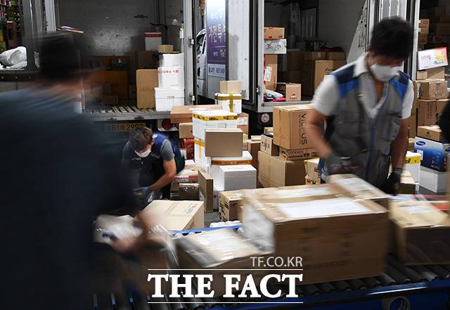 바쁘게 분류 작업 진행하는 배송업체 직원들.