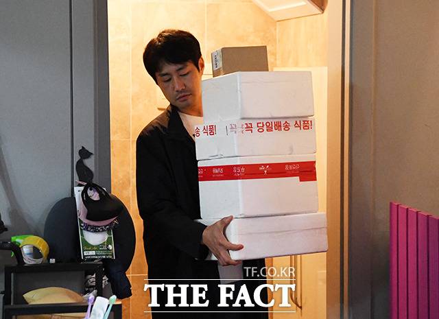 배송된 스티로폼 박스를 집 안으로 들고 들어오는 김 씨.