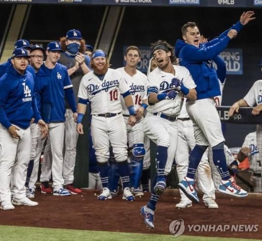 로스앤젤레스 다저스 선수들이 19일(한국시간) 미국 텍사스주 알링턴 글로브라이프필드에서 열린 미국프로야구 내셔널리그 챔피언십시리즈 7차전, 코디 벨린저가 7회말 역전 솔로 홈런을 치자 더그아웃 앞에서 기뻐하고 있다.[알링턴 EPA=연합뉴스]