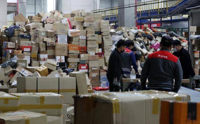 롯데택배 전국 총파업 돌입 출정식이 열린 27일 오전 서울 송파구 서울복합물류센터에서 택배기사들이 택배를 분류하고 있다. 뉴스1