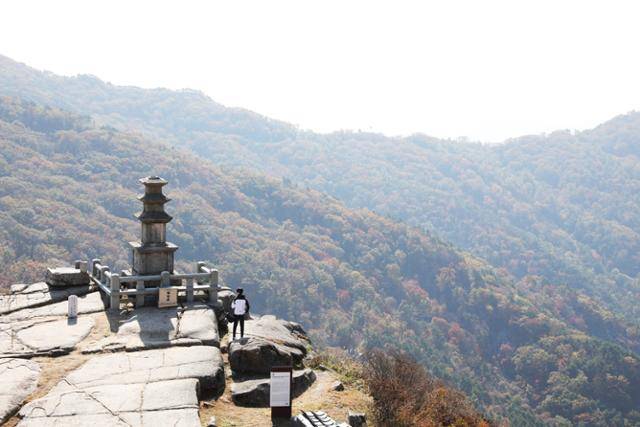 비슬산 정상 부근 대견사 삼층석탑 아래로 울긋불긋한 단풍이 산자락을 타고 흘러내리고 있다. ⓒ박준규
