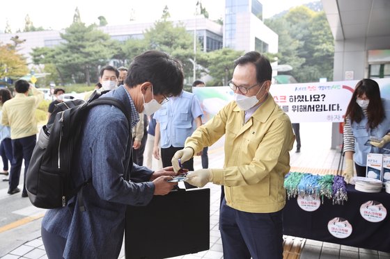 박상돈 천안시장(오른쪽)이 천안시청 현관 앞에서 마스크 의무 착용 캠페인을 벌이고 있다. [사진 천안시]