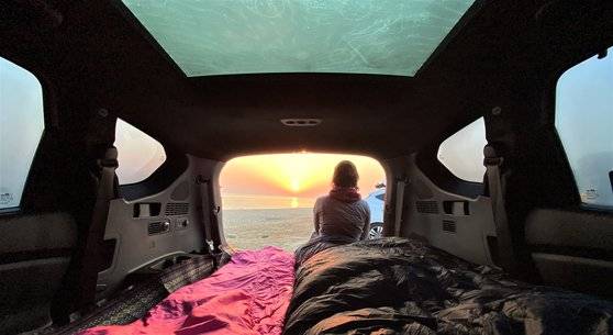 차박 중 강원도 강릉 순긋 해변에서 떠오르는 해를 바라보고 있는 한 남성. 김홍준 기자