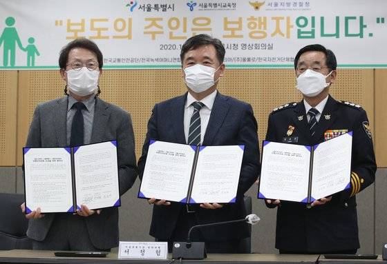 (왼쪽부터) 조희연 서울시교육감, 서정협 서울시장 권한대행, 장하연 서울지방경찰청장이 10일 서울 중구 서울시청에서 열린 '보행안전 공동협력 협약식'에서 기념촬영을 하고 있다. 뉴스1.