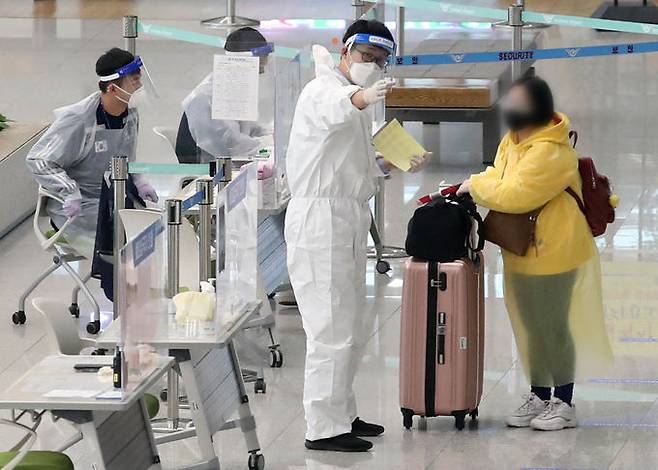 15일 인천국제공항2터미널에서 해외에서 입국한 시민이 신종 코로나바이러스 감염증(코로나19) 방역요원의&nbsp;안내를&nbsp;받고 있다. 인천공항=뉴스1