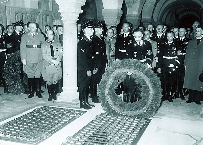 1938년 7월 나치 친위대장 하인리히 힘러가 독일 중부 하르츠 산맥에 위치한 크베들린부르크의 하인리히 국왕 묘소를 참배하고 있다. 국왕이 사망한 지 1000년이 되던 1936년부터 힘러는 나치 프로파간다에 활용하기 위해 국왕의 기일마다 이 도시를 방문했다.