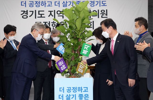 이재명 경기도지사가 지난 13일 오후 경기도 수원시 경기도지사 공관에서 열린 ‘경기도 지역구 국회의원 도정현안 간담회’에서 참석 의원들과 물주기 퍼포먼스를 하고 있다. /연합뉴스