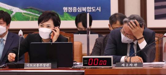 ‘골머리’ 싸매지만… : 김현미(왼쪽) 국토교통부 장관이 19일 국회 국토교통위원회에 출석해 통화하고 있는 가운데 손명수 국토부 제2차관이 손으로 머리를 감싸고 있다.  국회사진기자단