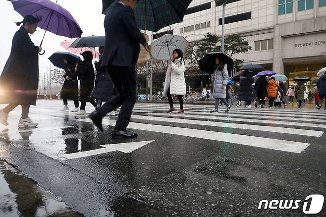 겨울비가 내린 7일 오후 서울 양천구 축제의 거리 앞에서 우산을 쓴 시민들이 발걸음을 옮기고 있다. 기상청 관계자는 "전국 대부분 지역에 비 또는 눈이 내리면서 가시거리가 짧아지고 도로가 미끄러운 곳이 많아 교통안전에 각별히 유의하기 바란다＂고 밝혔다. 2020.1.7/뉴스1 © News1 황기선 기자