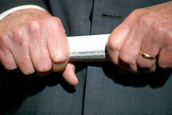 미국 상원 다수당인 공화당의 미치 매코널 원내대표가 2019년 10월 29일 민주당이 공식 발의한 트럼프 대통령에 대한 탄핵 결의안 서류를 말아 쥐고 기자들의 질문을 듣고 있다. [AP=연합뉴스]