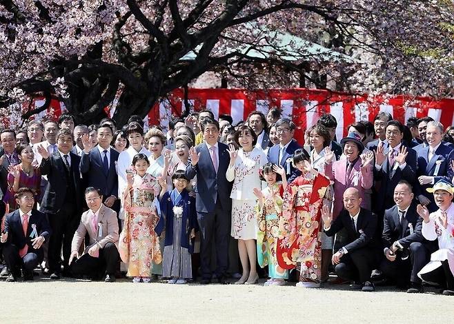 지난해 4월13일 아베 신조 일본 총리가 도쿄 신주쿠교엔에서 열린 ‘벚꽃을 보는 모임’에 참석해 참석자들과 기념사진을 찍는 모습. 일본 내각총리관저