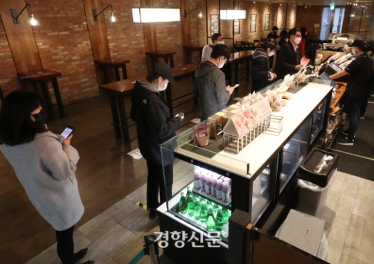 On November 24, when level-2 physical distancing was enforced in the greater Seoul area to prevent the spread of COVID-19, customers wait to place their orders at a cafe franchise in downtown Seoul. Kwon Do-hyun