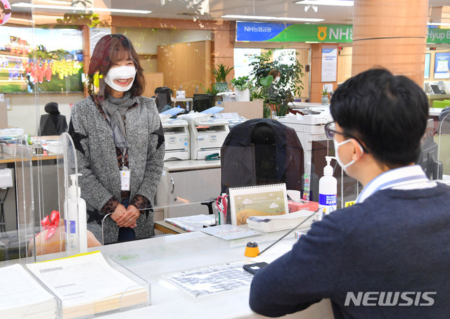 [울산=뉴시스] 구미현 기자 = 울산시 중구는 최근 코로나19 재확산 움직임에 따른 사회적 거리두기 강화와 관련해 지역 최초로 입 모양이 보이는 마스크를 직원에게 배부해 업무 시 대민활동에 시범 활용한다. 사진은 중구청 민원 담당 직원이 마스크를 착용하고 대민활동을 하고 있는 모습. 2020.11.25. (사진=울산시 중구 제공)photo@newsis.com