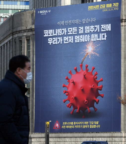 안전지대는 없습니다 - 25일 한 시민이 서울 중구 서울도서관 외벽에 걸린 ‘서울 천만시민 긴급 멈춤 기간’을 알리는 대형 플래카드 앞을 지나가고 있는 모습.정연호 기자 tpgod@seoul.co.kr