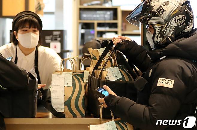 스타벅스가 27일부터 서울 강남구에 배달 전용 매장인 역삼이마트점을 열고 배달 서비스 시범운영에 들어갔다. 스타벅스 역삼이마트점은 고객 체류 및 주문 제품 직접 픽업이 가능했던 기존 스타벅스 매장과는 다르게 배달만 가능한 딜리버리 시범 매장으로 운영된다. 27일 스타벅스 역삼이마트점에서 라이더들이 배달에 분주한 모습을 보이고 있다. 2020.11.27/뉴스1 © News1 이성철 기자