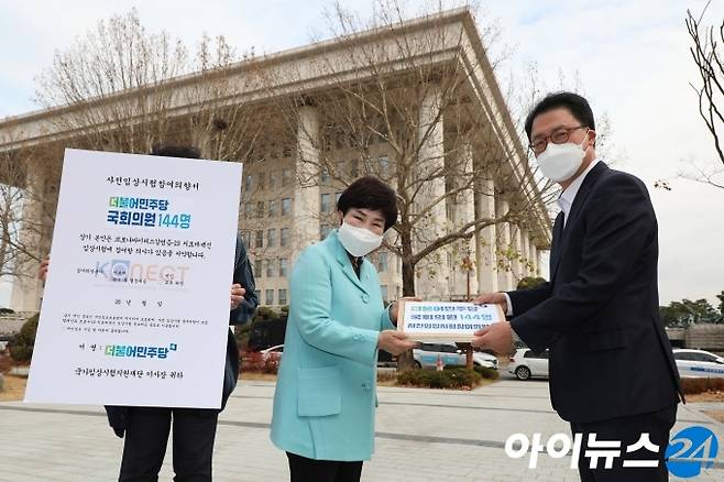 전혜숙 더불어민주당 국난극복 K-뉴딜위원회 공동위원장이 27일 오전 서울 여의도 국회 소통관에서 코로나 치료제 및 백신에 대한 임상시험 참여운동 기자회견을 마친 뒤 당 소속 144명의 코로나 임상시험 참여 의향서를  배병준 국가임상시험지원재단이사장에게 전달하고 있다.