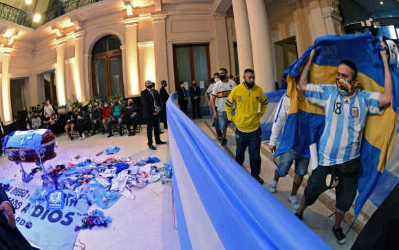아르헨티나 국민들이 부에노스아이레스의 대통령궁에 놓인 마라도나의 관을 보며 애도의 뜻을 표하고 있다.