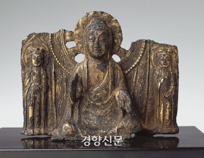 7세기 백제시대 작품으로 여겨지는 금동일광삼존불상. 본존은 좌상으로 8엽의 연화문이 장식된 원형광배를 갖추었다.|국립문화재연구소 도록에서