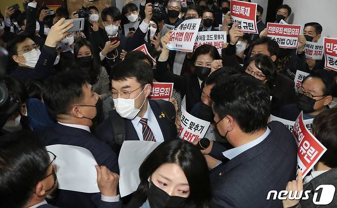 7일 오후 국민의힘 의원들이 더불어민주당의 고위공직자범죄수사처(공수처)법 개정안 등 입법 강행에 맞서 국회 법사위 회의실 앞에 집결해 규탄 구호를 외치는 가운데 민주당 김남국 의원이 국민의힘 의원들 사이를 뚫고 회의장으로 들어가고 있다. 2020.12.7/뉴스1 © News1 성동훈 기자