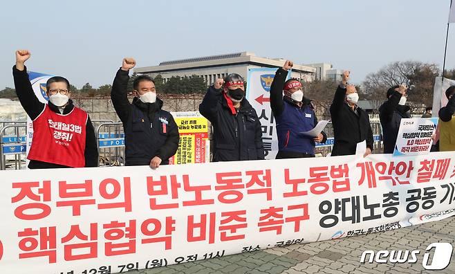 김동명 한국노총 위원장(왼쪽 세 번째부터)과 김재하 민주노총 비상대책위원장이 7일 오전 서울 여의도 국회 앞에서 열린 기자회견에서 국제노동기구(ILO) 협약을 비준하라는 구호를 외치고 있다. 양대노총은 국회가 노동권 강화를 골자로 하는 국제노동기구(ILO) 핵심협약을 즉각 비준하고 협약 기준에 미치지 못하는 정부의 노조법 개정안을 폐기할 것을 촉구했다. 2020.12.7/뉴스1 © News1 신웅수 기자