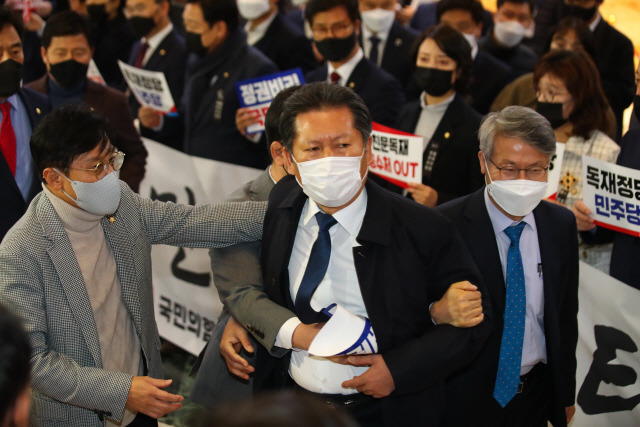 정청래 더불어민주당 의원이 10일 오후 국회 본회의장 앞에서 손피켓을 들고 시위하는 국민의힘 의원들과 말다툼을 하자 의원들이 말리고 있다. /연합뉴스