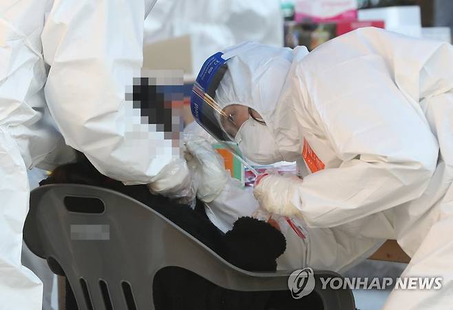 신규 확진자 발생한 학교서 코로나19 검사 (울산=연합뉴스) 김용태 기자 = 12일 오후 울산시 울주군 한 초등학교에 설치된 선별진료소에서 한 학생이 신종 코로나바이러스 감염증(코로나19) 검사를 받고 있다. 이날 이 학교 학생 1명이 코로나19 확진 판정을 받아 학생과 교직원 등 900여명을 대상으로 검사가 이뤄졌다. 2020.12.12 yongtae@yna.co.kr