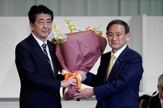 스가 요시히데(菅義偉) 일본 관방장관이 지난 9월 총재 경선이 끝난 뒤 아베 신조(安倍晋三) 총리로부터 축하 꽃다발을 받고 있다. [연합뉴스]