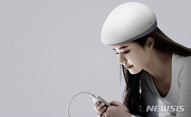 [서울=뉴시스] LG전자가 지난 10월 출시한 '프라엘 메디헤어'를 착용한 모습 (제공=LG전자)