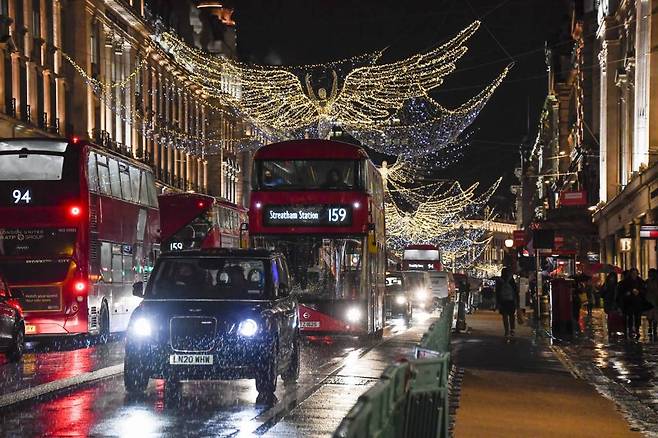 영국 런던의 리젠트 거리의 크리스마스 장식 밑으로 버스와 택시들이 지나고 있다./사진=AP,뉴시스