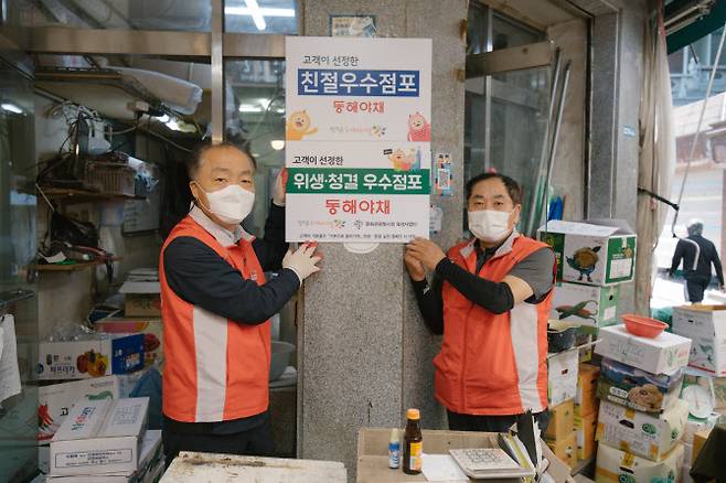 조봉환 소상공인시장진흥공단 이사장(왼쪽)이 서울 방학동도깨비시장을 방문해 위생·청결 우수점포로 선정된 ‘동해야채’ 앞에서 기념 사진을 찍고 있다. (사진=소상공인시장진흥공단)