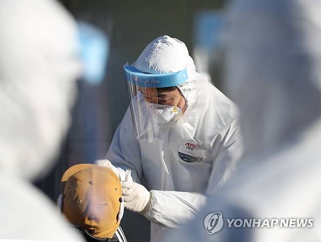 '조금만 참아보세요' (서울=연합뉴스) 김도훈 기자 = 코로나19 신규 확진자 수가 닷새 연속 1천명을 넘어선 지난 20일 오후 서울역 광장에 마련된 서울 중구 임시선별진료소에서 의료진이 검체 검사를 하고 있다. superdoo82@yna.co.kr