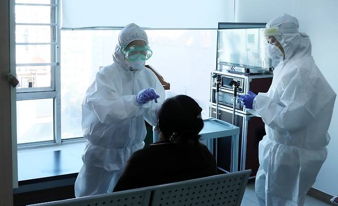 A health care worker at a hospital in Gyeonggi Province gets a nasopharyngeal swab test. (Yonhap)