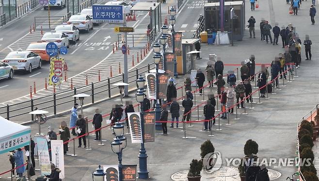 이어지는 발걸음 (서울=연합뉴스) 서명곤 기자 =  26일 오전 서울역 광장에 설치된 중구 임시 선별검사소에서 시민들이 신종 코로나바이러스 감염증 검사를 받기 위해 차례를 기다리고 있다. 중앙방역대책본부는 이날 0시 기준으로 코로나19 신규 확진자가 1천132명 늘어 누적 5만5천902명이라고 밝혔다. 2020.12.26 seephoto@yna.co.kr