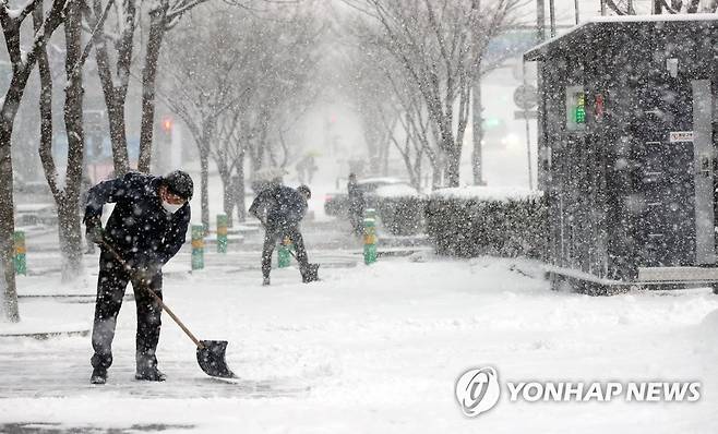 치워도 치워도 쌓이는 눈 (광주=연합뉴스) 천정인 기자 = 대설주의보가 내려진 30일 오전 광주 서구 상무지구에서 건물 관계자들이 인도에 쌓인 눈을 치우고 있다. 2020.12.30 iny@yna.co.kr