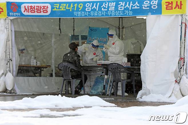 사흘동안 눈이 내리고 있는 31일 오후 광주시청 광장에 설치된 코로나19 임시 선별검사소에서 보건당국 관계자들이 시민들의 검체를 채취하고 있다. 2020.12.31/뉴스1 © News1 황희규 기자