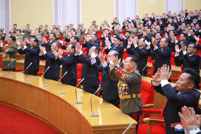 북한 노동당 제8차 대회를 앞두고 지난 30일 열린 대표증 수여식에서 참석자들이 자리에서 일어서 손뼉을 치고 있다. 김일성·김정일 부자에게 대표증을 수여했다는 발표가 나온 순간으로 추정된다. 앞줄 왼쪽부터 김수길 인민군 총정치국장(대장), 최부일 노동당 군정지도부장, 당중앙위 부위원장인 김영철·박태덕·최휘·리일환, 박정천 인민군 총참모장(원수), 허철만 노동당 간부부장. /조선중앙통신 연합뉴스