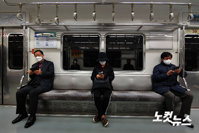 서울지하철 5호선에서 마스크를 쓴 시민들이 간격을 두고 앉아 있다. 황진환 기자