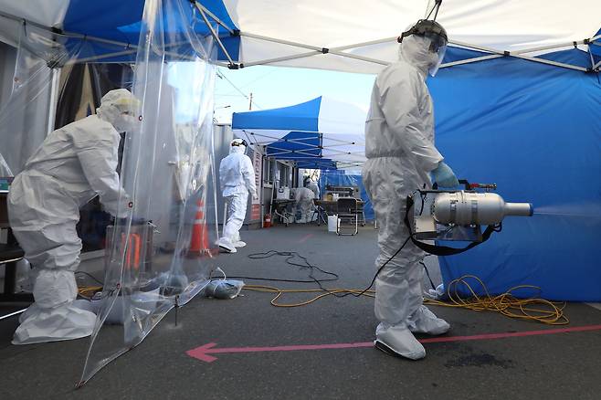 세밑 한파가 이어진 지난달 31일 대구 수성구보건소 선별진료소에서 신종 코로나바이러스 감염증(코로나19) 검사에 투입된 의료진이 대기장소를 소독하고 있다. 뉴스1