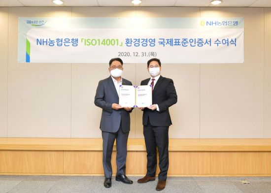 지난 12월 31일 서울시 중구에 위치한 농협은행 본점에서 NH농협은행 지준섭 농업·녹색금융부문 부행장(왼쪽)과 로열서트코리아 이권상 대표(오른쪽)가 ISO 14001 인증서 수여식을 갖고 기념촬영을 하고 있다.
