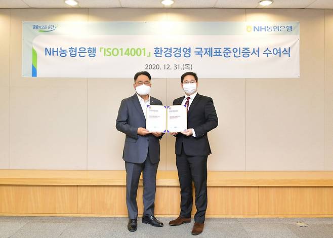 지난해 12월 31일 서울시 중구 농협은행 본점에서 NH농협은행 지준섭 농업·녹색금융부문 부행장(왼쪽)과 로열서트코리아 이권상 대표(오른쪽)가 ISO 14001 인증서 수여식을 갖고 기념촬영을 하고 있다.