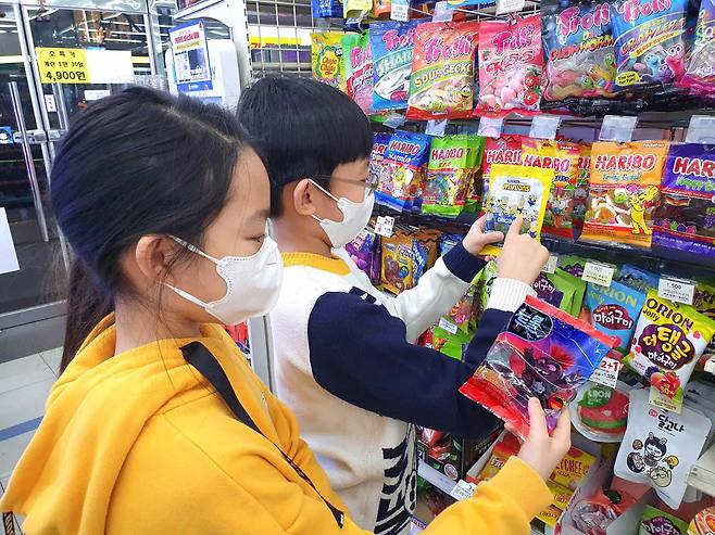 어린이들이 GS25에서 유니버설 캐릭터 상품을 고르고 있다.