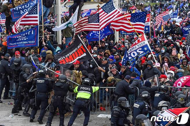 6일(현지시간) 도널드 트럼프 미국 대통령 지지하는 시위대가 워싱턴 의사당으로 몰려들면서 경찰과 충돌을 하고 있다. © AFP=뉴스1 © News1 우동명 기자