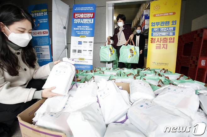 지난달 21일 광주 북구 긴급재난 구호품 보관소에서 직원들이 자가격리자들에게 보낼 햇반과 김 등 식료품 15종이 담긴 생필품을 정리하고 있다.(광주북구 제공)2020.12.21/뉴스1 © News1